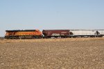 BNSF 7695, the famed "golden swoosh" locomotive, brings up the rear of an eastbound grain train